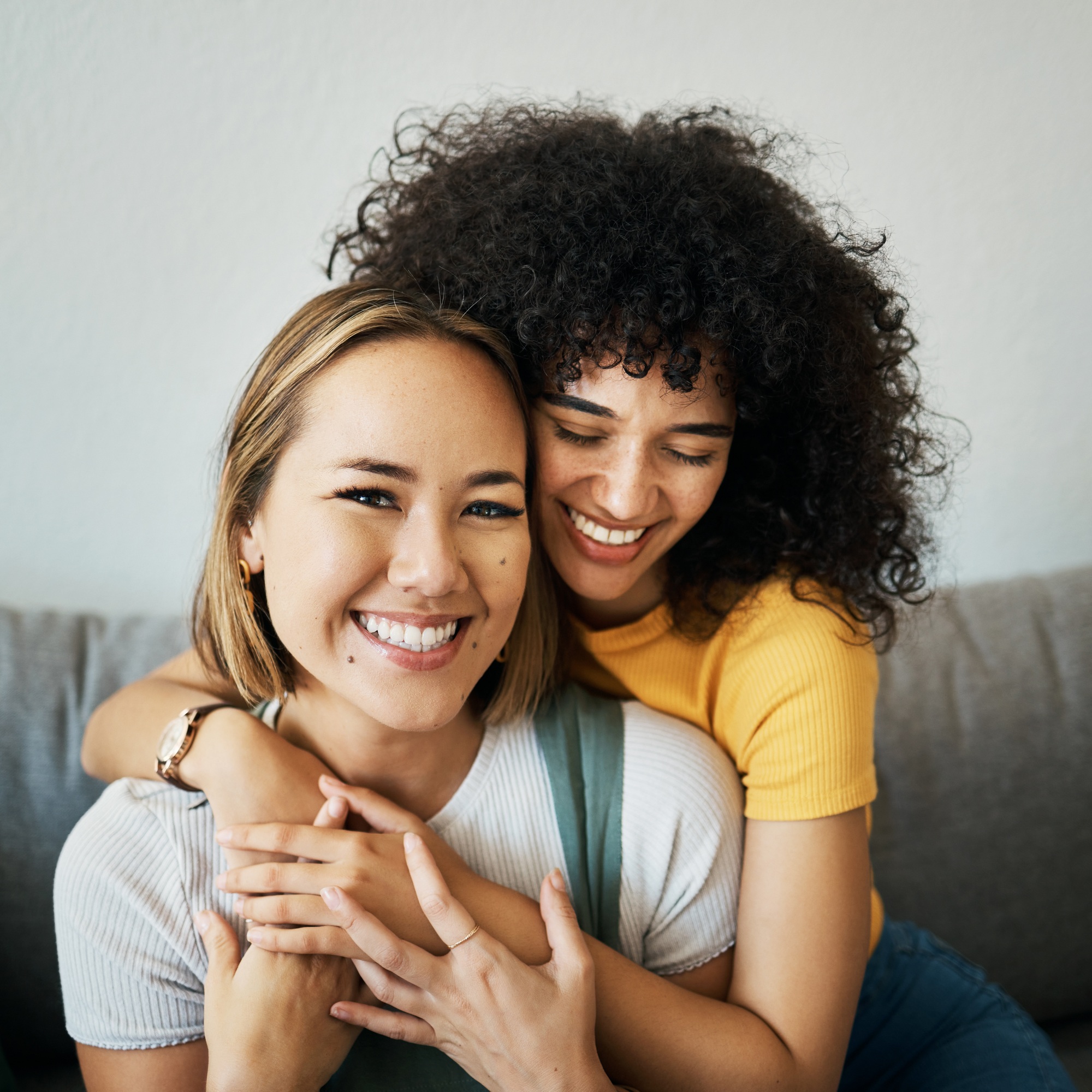 Lesbian, couple and portrait of hug on sofa in home, property or apartment with love, support and h